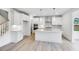 Modern white kitchen with a large island, stainless steel appliances, and stylish pendant lighting at 1705 Clydner Dr, Cary, NC 27523