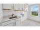 The well-lit laundry room features a quartz countertop, white cabinets and a window at 1705 Clydner Dr, Cary, NC 27523
