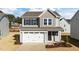 Two-story house with gray siding, white garage door, and landscaping at 26 Wildflower Cir, Clayton, NC 27520