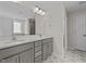 Double vanity bathroom with a large mirror and patterned tile flooring at 34 Windflower Ct, Clayton, NC 27520