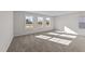 Spacious bedroom featuring three windows and wall-to-wall carpet at 34 Windflower Ct, Clayton, NC 27520