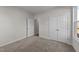 Bright bedroom with carpet flooring, double door closet and an additional doorway at 34 Windflower Ct, Clayton, NC 27520