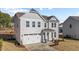Two-story house with gray siding, white garage door, and teal front door at 34 Windflower Ct, Clayton, NC 27520