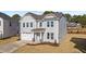 Two-story house with gray siding, white garage doors, and landscaping at 34 Windflower Ct, Clayton, NC 27520