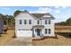 Two-story house with gray siding, white garage door, and a teal front door at 34 Windflower Ct, Clayton, NC 27520