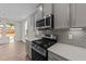 Modern kitchen with gray cabinets, quartz countertops, and stainless steel appliances at 34 Windflower Ct, Clayton, NC 27520