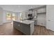 Modern kitchen with island, gray cabinets, and quartz countertops at 34 Windflower Ct, Clayton, NC 27520