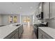 Modern kitchen with gray cabinets, quartz countertops, and stainless steel appliances at 34 Windflower Ct, Clayton, NC 27520