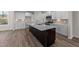Modern kitchen with island, stainless steel appliances, and wood-look floors at 36 Railcar Way, Clayton, NC 27520