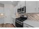 Stainless steel appliances and herringbone backsplash in this modern kitchen at 36 Railcar Way, Clayton, NC 27520