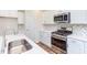 Modern kitchen with white cabinets, stainless steel appliances, and herringbone backsplash at 37 Baird Cv Ln, Angier, NC 27501