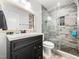 Modern bathroom featuring wood floors, dark vanity, and a glass-enclosed shower at 4236 Lake Ridge Dr, Raleigh, NC 27604