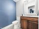 Elegant powder room featuring a modern vanity with wooden cabinets and neutral gray paint at 4236 Lake Ridge Dr, Raleigh, NC 27604