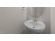 Powder room featuring a pedestal sink, chrome fixtures, and a round mirror at 48 Railcar Way, Clayton, NC 27520