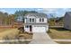Inviting gray two-story home with well-manicured lawn, a two-car garage, and a bright, sunny sky at 48 Railcar Way, Clayton, NC 27520