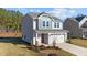 Charming two-story home with gray siding, a red front door, a two-car garage, and a landscaped yard at 48 Railcar Way, Clayton, NC 27520