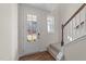 Inviting foyer with hardwood floors, a glass-paneled door, and a staircase at 48 Railcar Way, Clayton, NC 27520