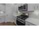 Modern kitchen featuring stainless steel appliances, white cabinets, stone countertops, and wood floors at 48 Railcar Way, Clayton, NC 27520