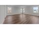 Bedroom boasting hardwood floors, neutral walls, three windows, and bright natural light at 645 Silvercomet Dr, Knightdale, NC 27545