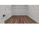 Walk-in closet with hardwood floors, white shelving, and door at 645 Silvercomet Dr, Knightdale, NC 27545