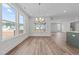 Open dining area boasts natural light, modern lighting, and wood flooring at 645 Silvercomet Dr, Knightdale, NC 27545