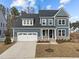 Charming two-story home featuring blue siding, stone accents, and a well-maintained lawn at 645 Silvercomet Dr, Knightdale, NC 27545