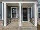 View of a home's front porch with stone accents and white columns at 645 Silvercomet Dr, Knightdale, NC 27545