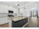 Modern kitchen with island, granite countertops, and stainless steel appliances at 747 Creekway Dr, Fuquay Varina, NC 27526