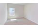Well-lit bedroom featuring neutral carpeting and a window at 76 Brooklynn Trl, Angier, NC 27501