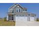 Two-story house with gray siding, white trim, and a three-car garage at 86 Barn Door Dr, Lillington, NC 27546