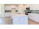 Modern kitchen with white cabinets, quartz countertops, and stainless steel appliances at 86 Barn Door Dr, Lillington, NC 27546
