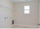 Laundry room with window, shelving, and space for washer/dryer at 86 Barn Door Dr, Lillington, NC 27546