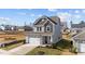 Two-story house with gray siding, white garage doors, and a front yard at 86 Brooklynn Trl, Angier, NC 27501