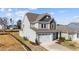 Two-story house with gray siding, white garage door, and landscaping at 86 Brooklynn Trl, Angier, NC 27501