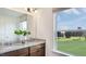 Bathroom featuring a double sink vanity with a granite countertop and a window overlooking the backyard at 8705 Wardle Ct, Wake Forest, NC 27587
