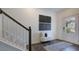 Bright foyer with hardwood flooring, staircase, decorative art, bench, and white front door at 8705 Wardle Ct, Wake Forest, NC 27587