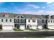Charming townhome exteriors, showing various color schemes and integrated garages, all under a bright blue sky at 8712 Wardle Ct, Wake Forest, NC 27587