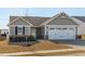 Gray siding house with white garage door and landscaping at 8798 Kenridge Ln, Fuquay Varina, NC 27526