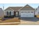 Gray exterior with white garage door, landscaping, and a stone accent at 8798 Kenridge Ln, Fuquay Varina, NC 27526