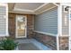 White front door with glass panel and stone surround at 8798 Kenridge Ln, Fuquay Varina, NC 27526