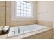 The luxurious bathroom includes a large soaking tub with tile surround and hardware at 104 Warm Wood Ln, Apex, NC 27539