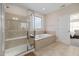 Bright bathroom featuring a glass shower, soaking tub and tile flooring at 104 Warm Wood Ln, Apex, NC 27539