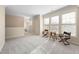 Bright bonus room with neutral walls, carpet and large windows with seating and chess table at 104 Warm Wood Ln, Apex, NC 27539