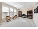Bright bonus room with neutral walls, carpet, piano, bookcases and large windows with seating and chess table at 104 Warm Wood Ln, Apex, NC 27539