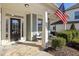 Front porch with white columns, wicker furniture, and an American flag at 104 Warm Wood Ln, Apex, NC 27539