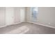 Bright bedroom features neutral carpet, paint, a window, and two closet doors at 107 Myers Farm Ct, Cary, NC 27519