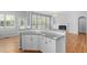 Open kitchen area with granite countertops, white cabinetry, and natural light from large windows at 107 Myers Farm Ct, Cary, NC 27519