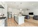 Open concept kitchen and living area with white cabinets, island and gray sofas at 1135 Laurelwood Dr, Durham, NC 27705