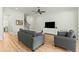 Bright living room features hardwood floors, gray sofas, and a view of the staircase at 1135 Laurelwood Dr, Durham, NC 27705