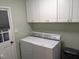 Laundry room with white cabinets and matching washer/dryer set at 1408 Brigham Rd, Chapel Hill, NC 27517